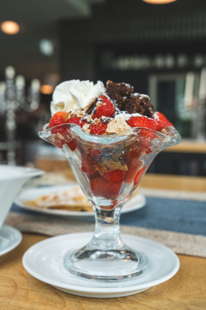 Erdbeerbecher mit Brownie-St&uuml;cken, Sahne und Schokoladenraspeln.