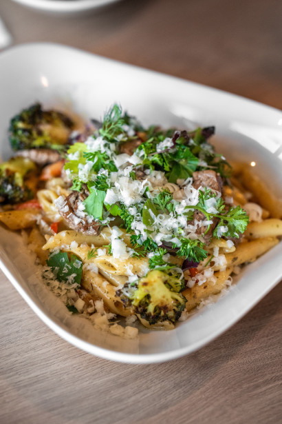 Teller mit Pasta, Gem&uuml;se und frisch geriebenem Parmesan.