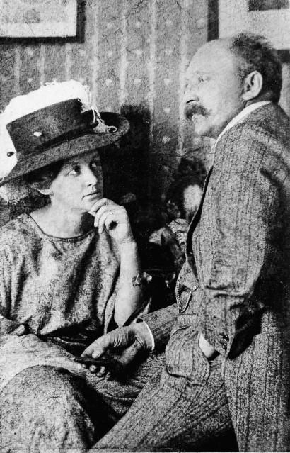 Ada Nolde sitzt auf einem Stuhl mit Kleid und gro&szlig;em Hut, Emil Nolde sitzt leicht erh&ouml;ht auf einem Hocker in Frack.