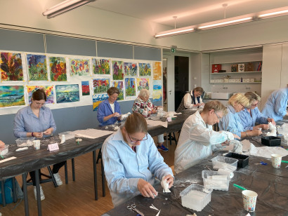 Malkursteilnehmende arbeiten konzentriert mit Gips in der Malschule Seeb&uuml;ll.